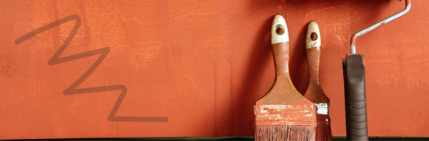 Paint brushes leaning against a wall
