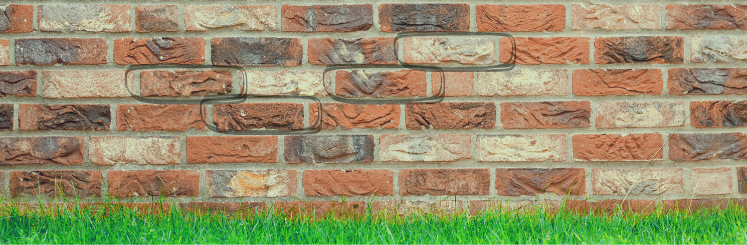 Brick wall with grass at its base