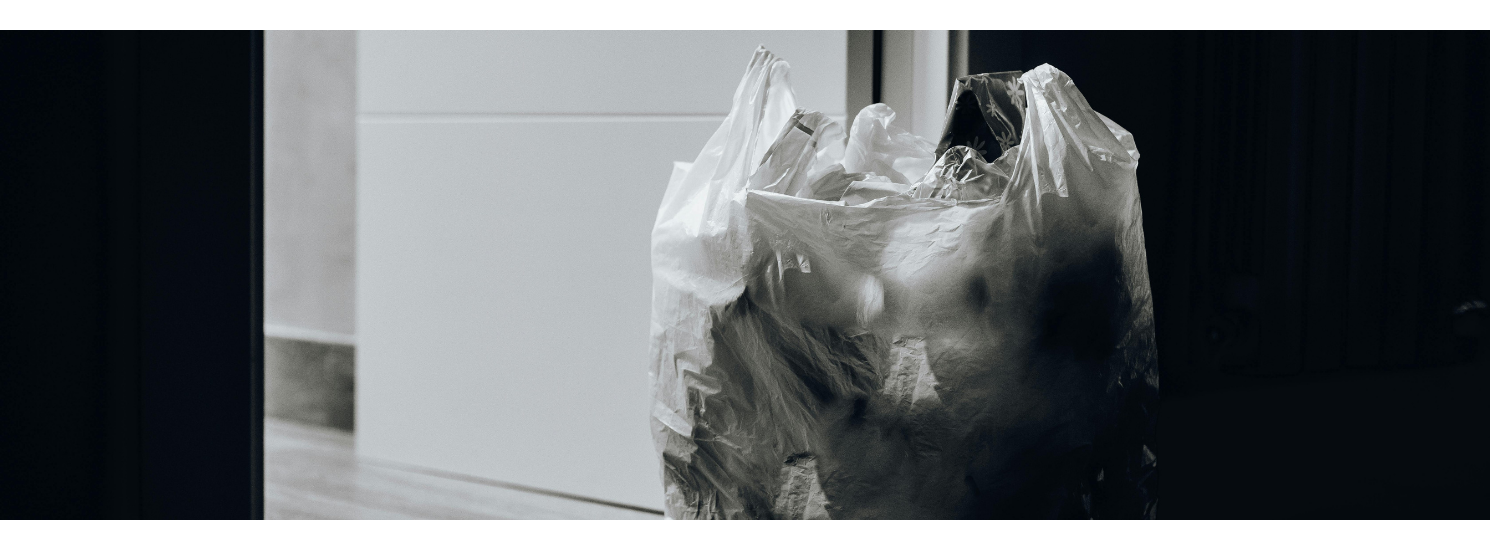 A full bin bag by an open door