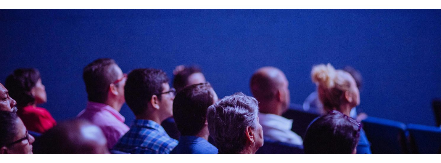 People sitting in a cinema looking at a screen