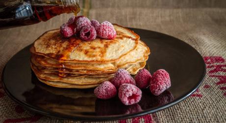 A big pile of pancakes and frozen raspberries