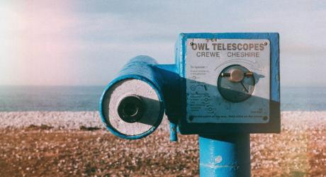 A vintage telescope on a beach