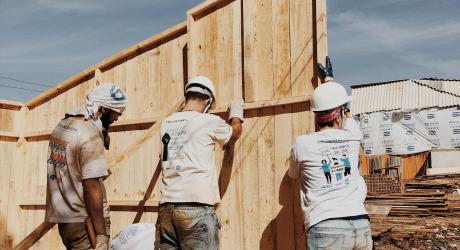 Three men building a new wall