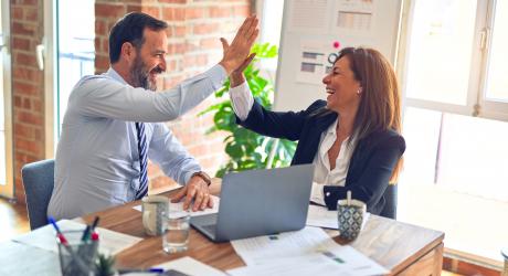 Two office workers high-fiving