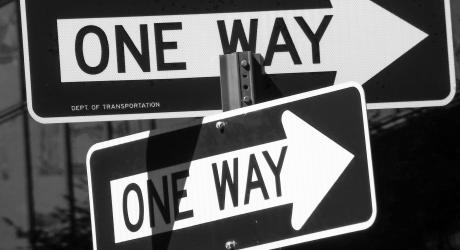 Two one way signs pointing in opposite directions