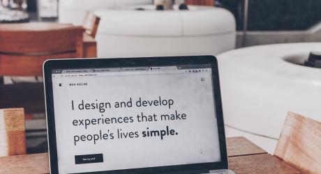 Screen on a laptop that says "I design and develop experiences that make people's lives simple".