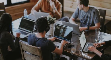 Three men on laptops working on code