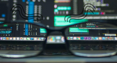 Glasses sitting in front of computer screens