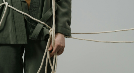 A man standing tangled up in rope