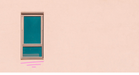 A plain pink wall with a single window in it
