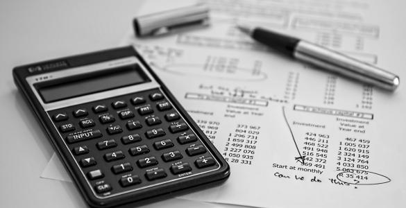 calculator and pen on a balance sheet