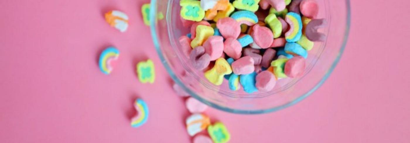 A bowl of rainbow coloured cereal in a clear bowl