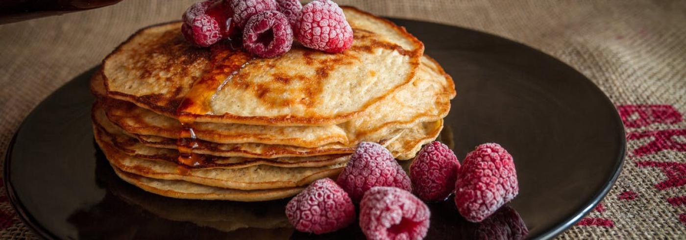 A big pile of pancakes and frozen raspberries