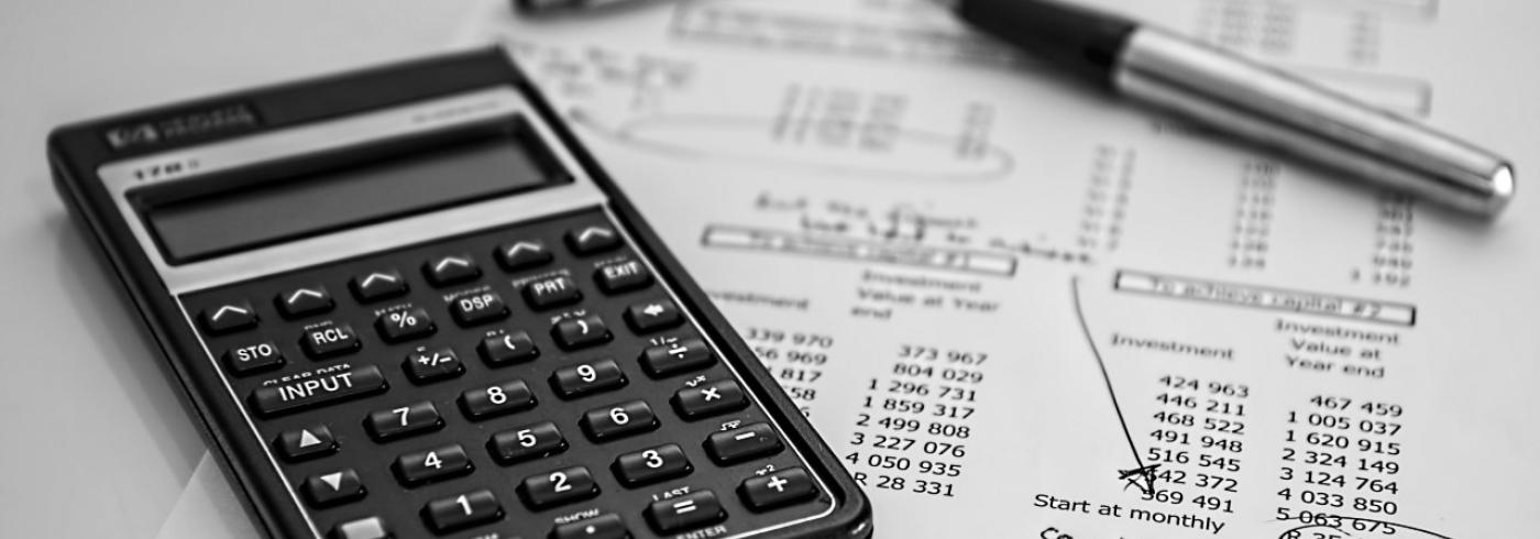 calculator and pen on a balance sheet