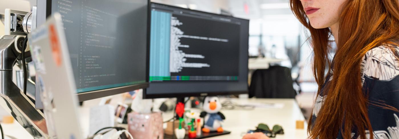 Woman coding on a desktop computer