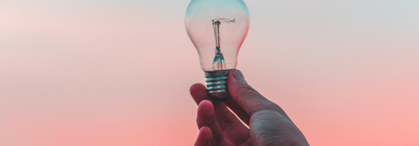 A hand holding a lightbulb