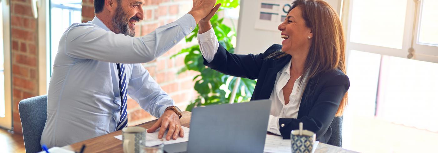 Two office workers high-fiving