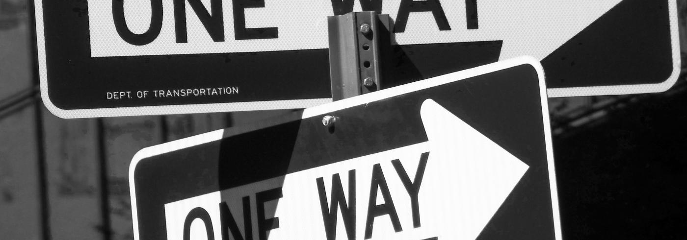 Two one way signs pointing in opposite directions