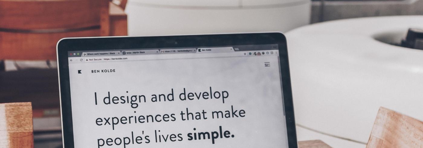 Screen on a laptop that says "I design and develop experiences that make people's lives simple".