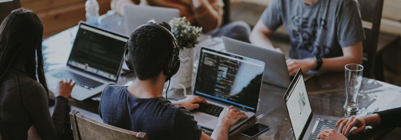 Three men on laptops working on code