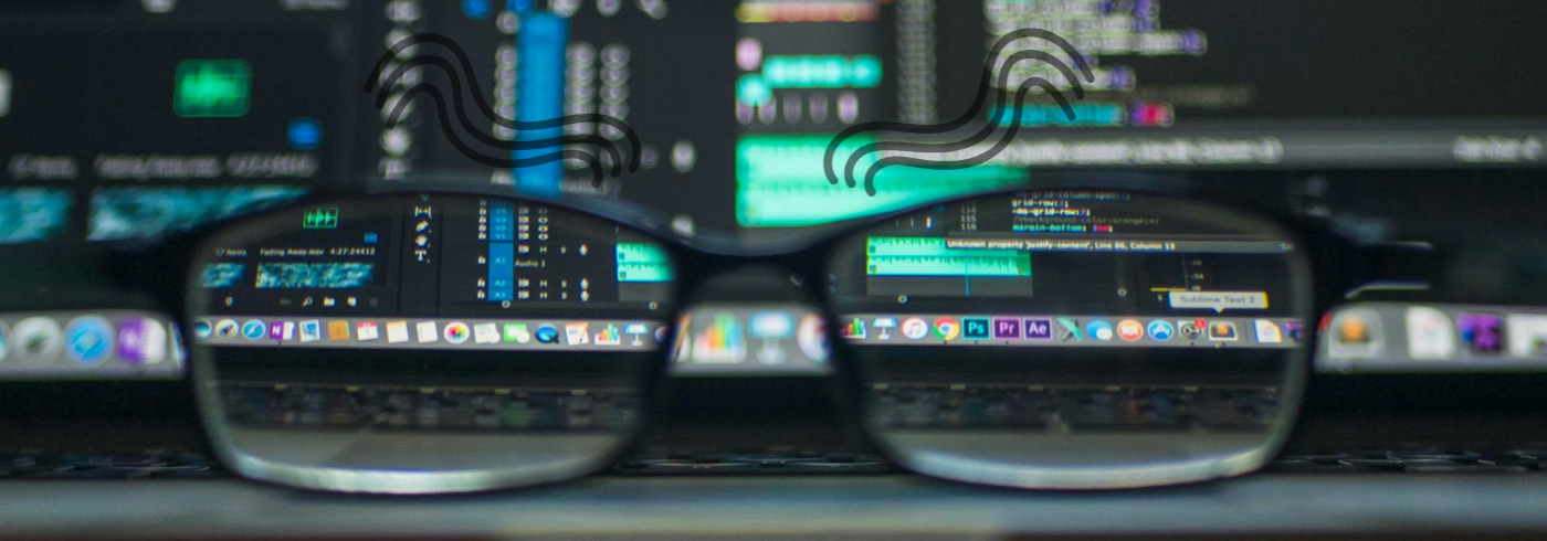 Glasses sitting in front of computer screens
