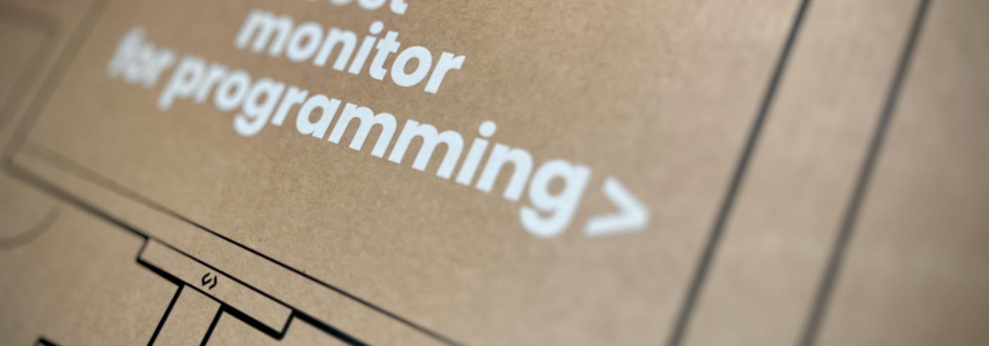 Cardboard box with the text, the best monitor for programming printed on the side.