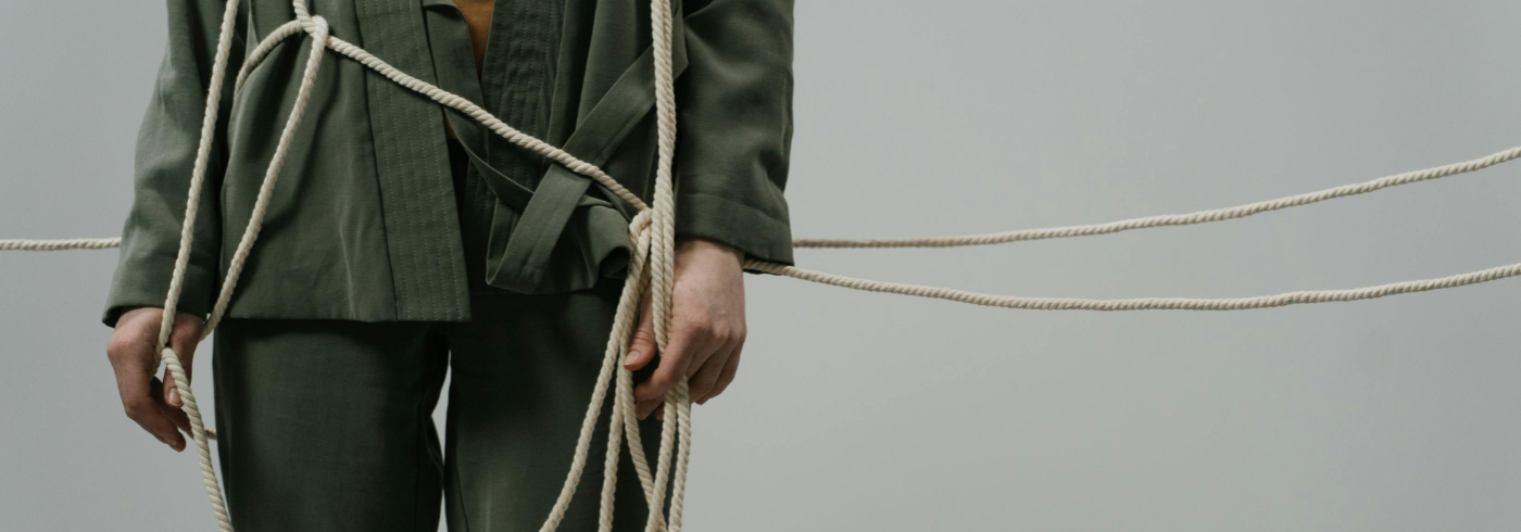 A man standing tangled up in rope