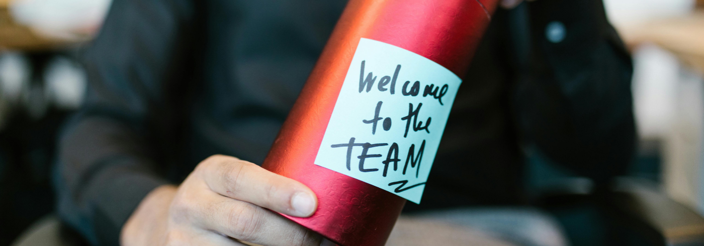 A man with a gift welcoming him to the team