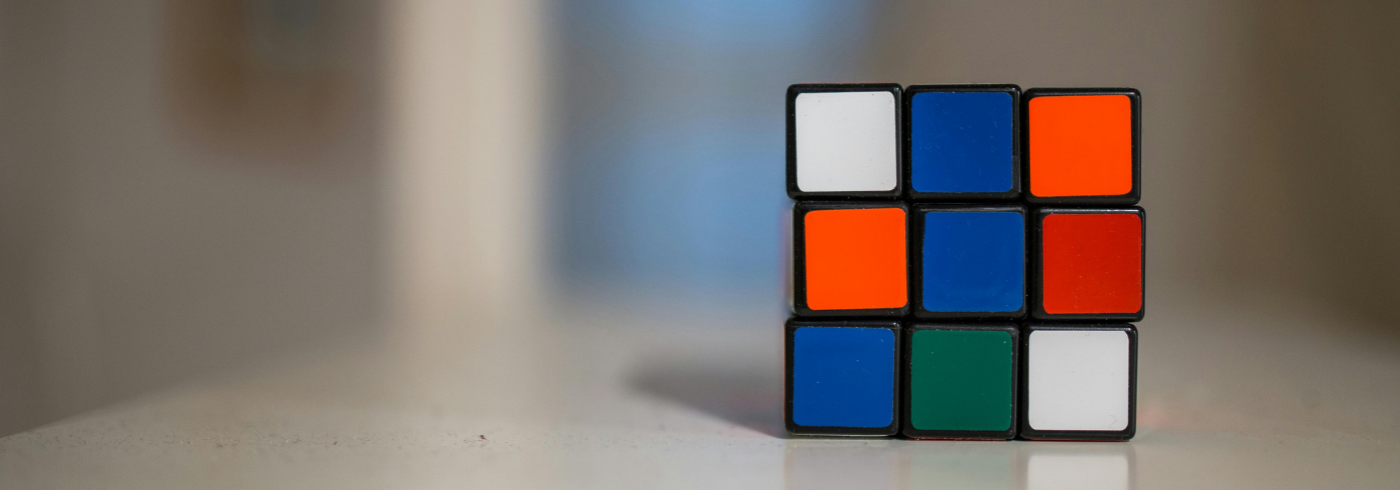 An unsolved Rubiks cube on a table