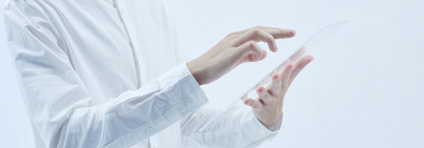 A person in a white lab coat holding a tablet